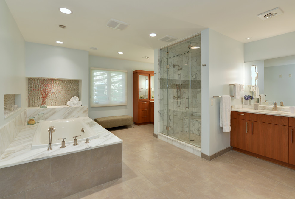 Design ideas for an expansive contemporary master bathroom in Milwaukee with flat-panel cabinets, medium wood cabinets, a corner tub, an alcove shower, an integrated sink, beige floor, a hinged shower door and multi-coloured benchtops.