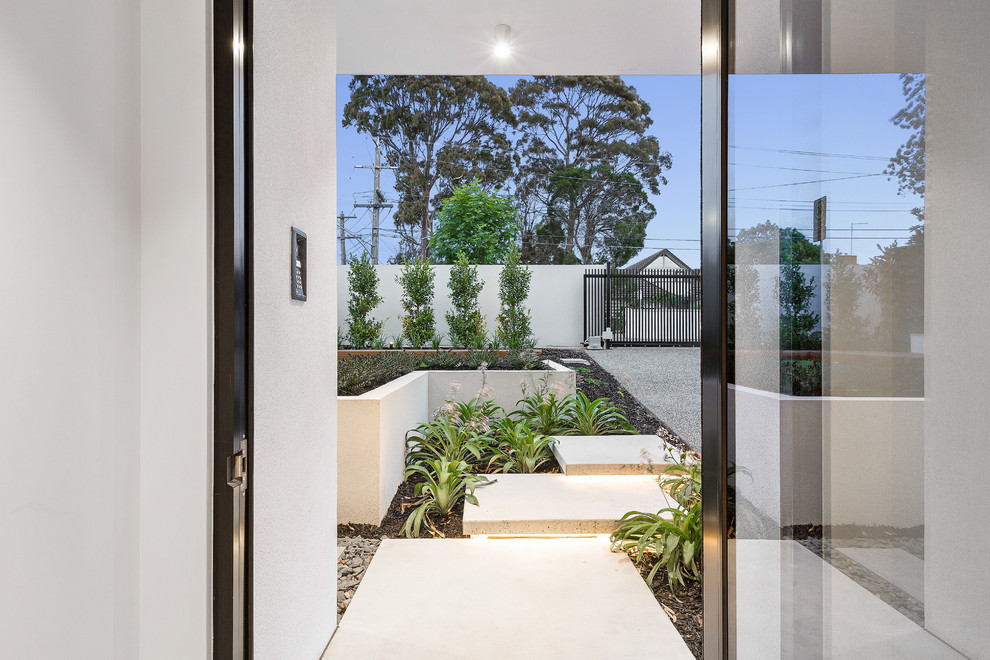 This is an example of a mid-sized modern front door in Melbourne with white walls, concrete floors, a pivot front door, a glass front door and grey floor.