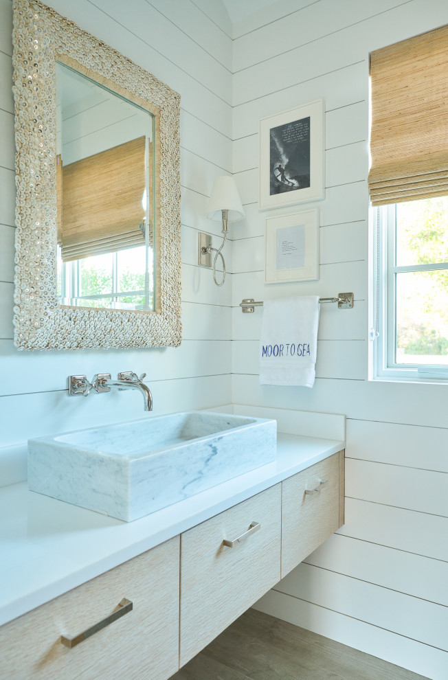 Beach style 3/4 bathroom in New York with flat-panel cabinets, light wood cabinets, white walls, light hardwood floors, a vessel sink, engineered quartz benchtops, brown floor, white benchtops, a single vanity, a floating vanity, vaulted and planked wall panelling.