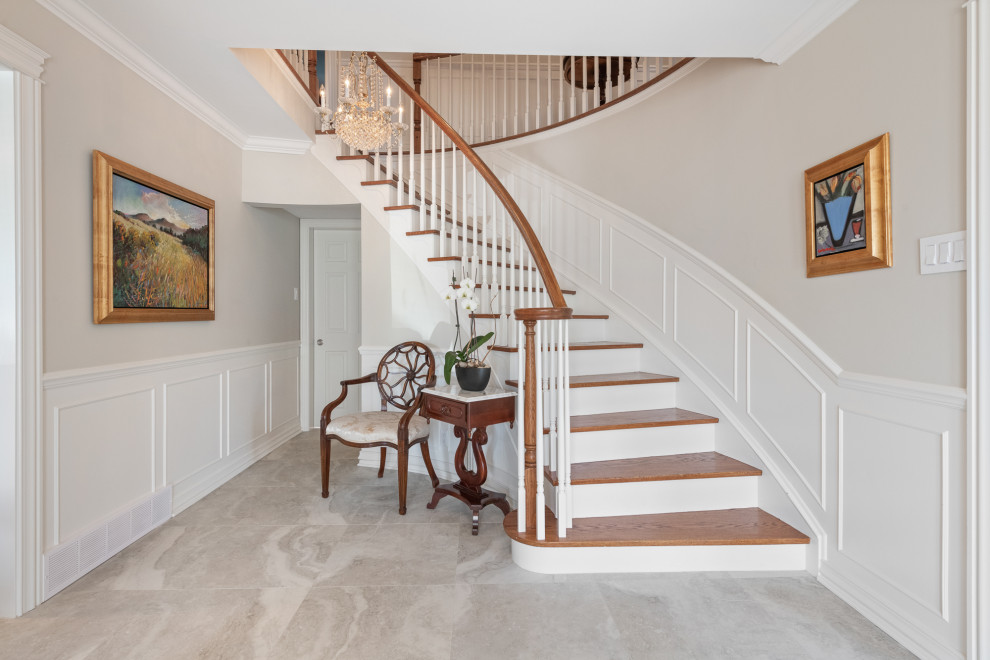 This is an example of a mid-sized traditional wood curved staircase in Ottawa with painted wood risers, wood railing and decorative wall panelling.