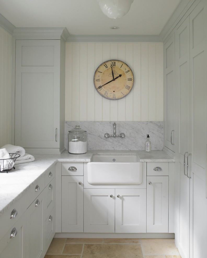 Design ideas for a traditional laundry room in New York with a farmhouse sink, limestone floors and grey benchtop.