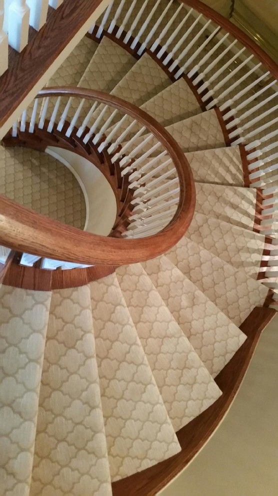 Expansive contemporary carpeted spiral staircase in Detroit with carpet risers.