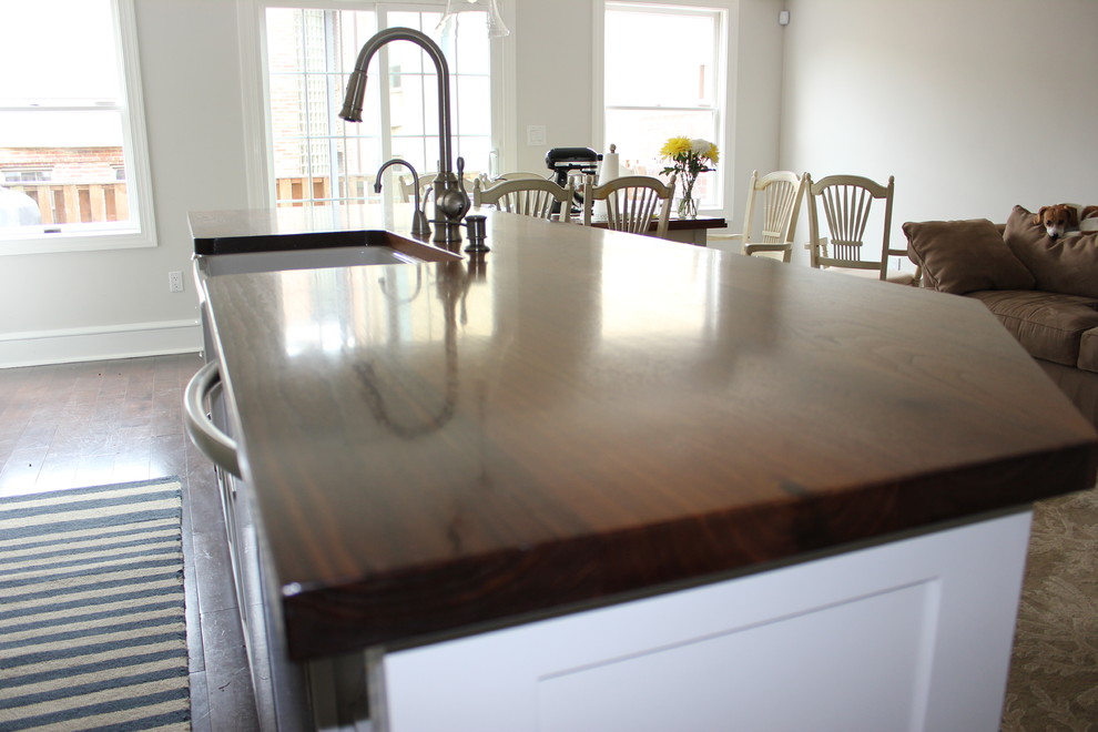 Eat-in kitchen - large transitional galley dark wood floor eat-in kitchen idea in Baltimore with a farmhouse sink, shaker cabinets, white cabinets, wood countertops, white backsplash, ceramic backsplash, stainless steel appliances and an island