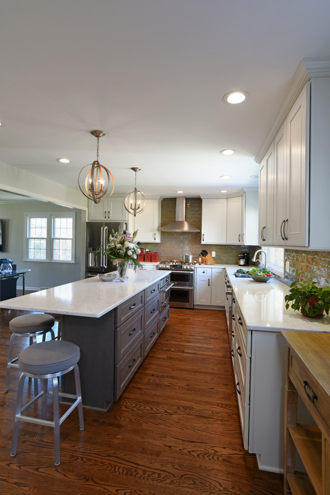 Eat-in kitchen - transitional l-shaped medium tone wood floor eat-in kitchen idea in Orange County with a double-bowl sink, shaker cabinets, white cabinets, marble countertops, gray backsplash, glass tile backsplash, stainless steel appliances and an island