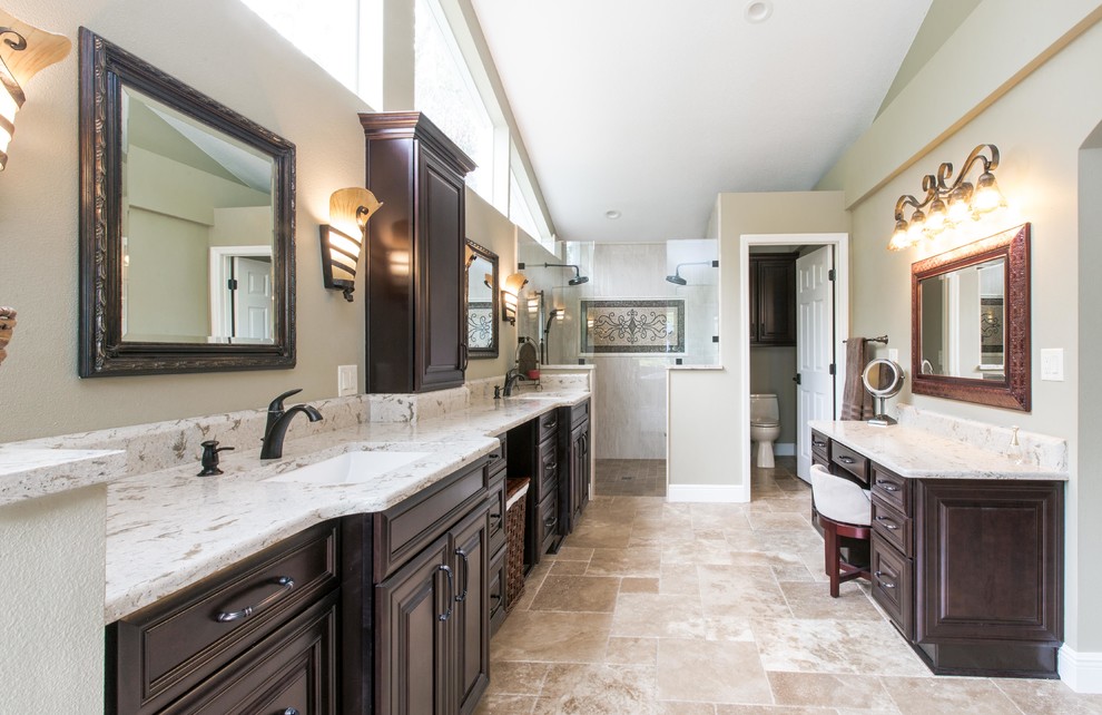 This is an example of a large traditional master bathroom in Orlando with raised-panel cabinets, brown cabinets, a corner shower, multi-coloured tile, porcelain tile, travertine floors, an undermount sink, engineered quartz benchtops and multi-coloured floor.