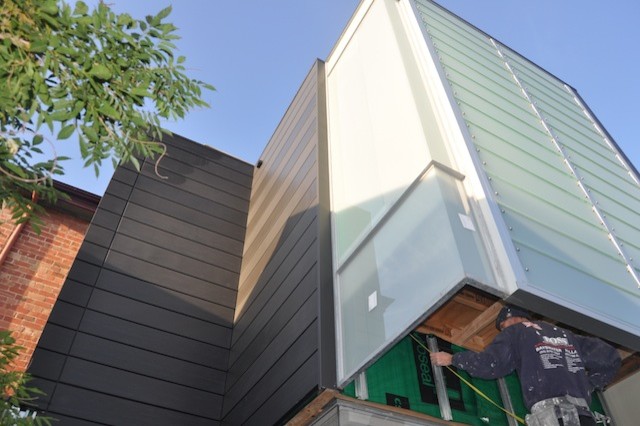 Small contemporary two-storey black exterior in Melbourne with metal siding and a flat roof.