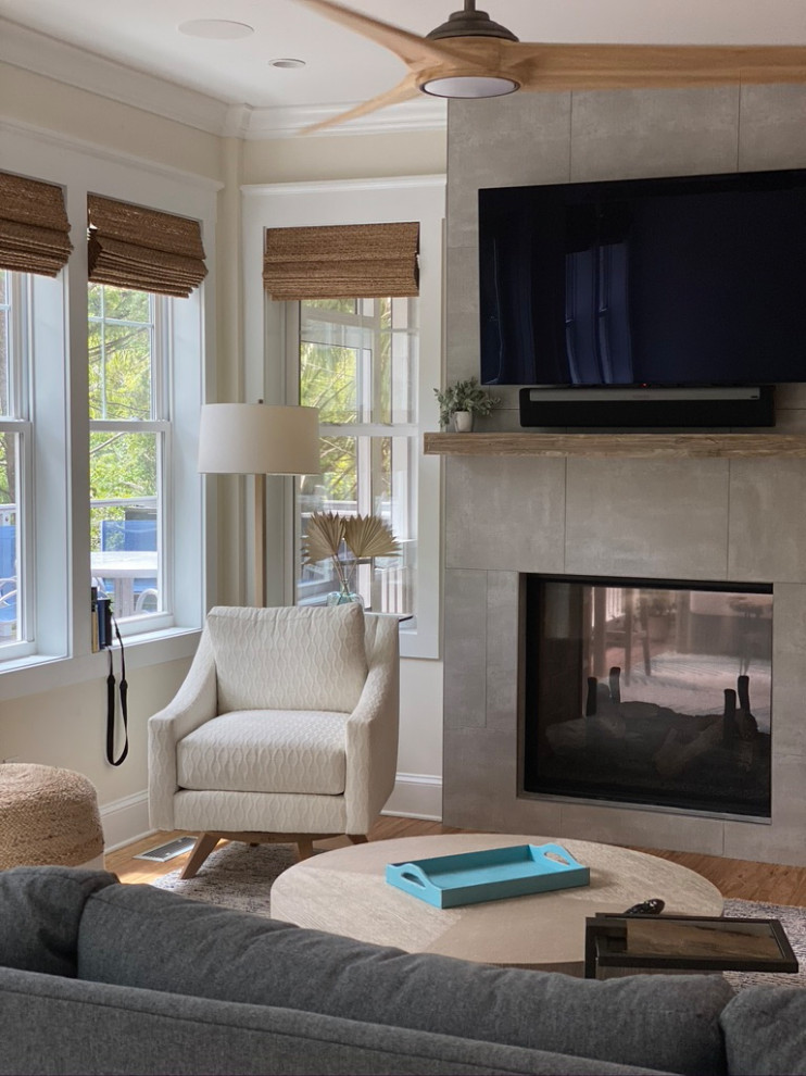 This is an example of an expansive beach style open concept living room in Other with bamboo floors, brown floor, white walls, a two-sided fireplace, a tile fireplace surround and a wall-mounted tv.