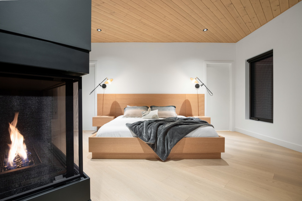 バンクーバーにあるコンテンポラリースタイルのおしゃれな主寝室 (淡色無垢フローリング、両方向型暖炉、板張り天井)