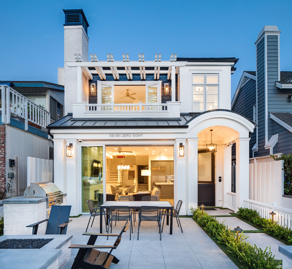 Beach style two-storey house exterior in Orange County with a metal roof.