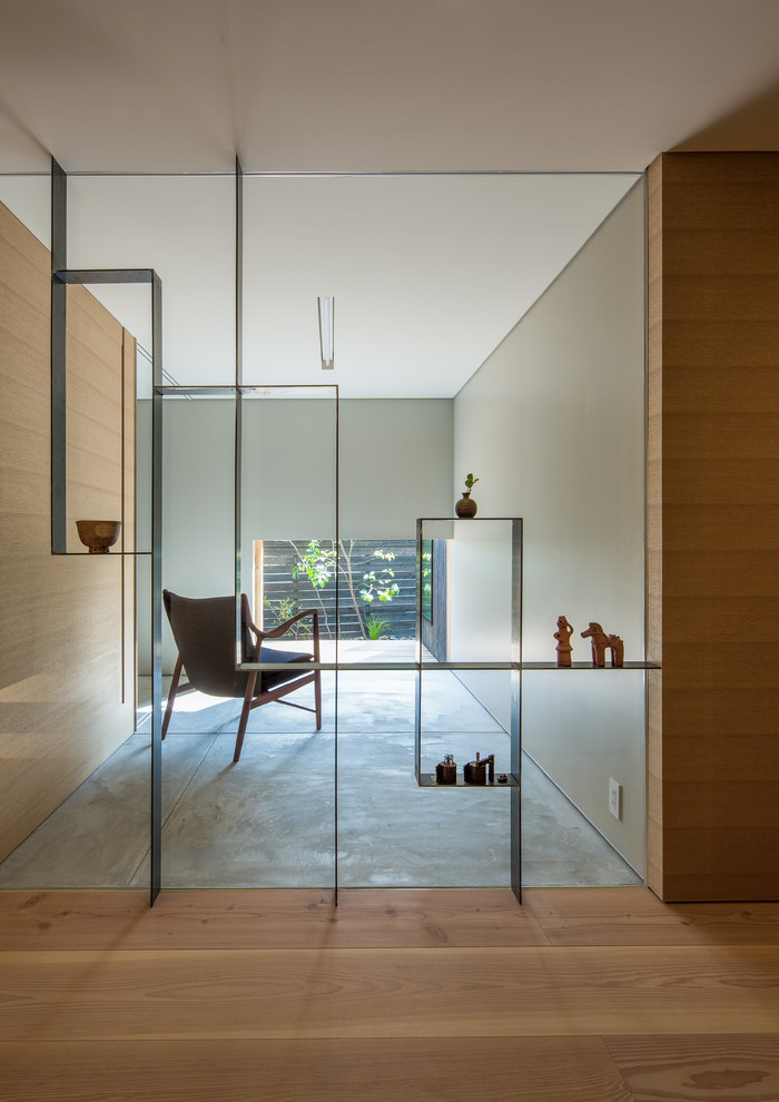 Mid-sized modern hallway in Kobe with grey walls and concrete floors.