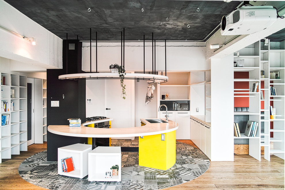 Mid-sized industrial u-shaped open plan kitchen in Tokyo with an undermount sink, flat-panel cabinets, white cabinets, black appliances, porcelain floors and with island.