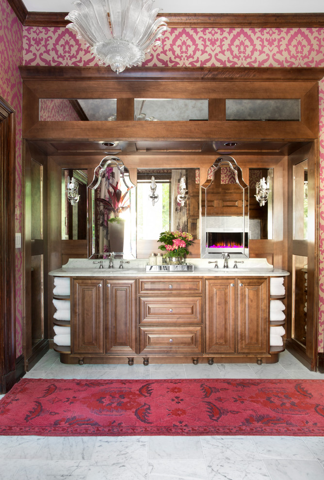 Inspiration for a large transitional master bathroom in Atlanta with raised-panel cabinets, medium wood cabinets, a freestanding tub, stone tile, pink walls, marble floors, an undermount sink and marble benchtops.