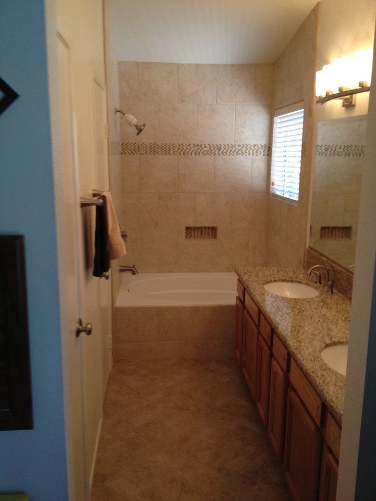 Photo of a mid-sized traditional master bathroom in Orange County with recessed-panel cabinets, medium wood cabinets, granite benchtops, a drop-in tub, a shower/bathtub combo, multi-coloured tile, porcelain tile, beige walls, porcelain floors and an undermount sink.
