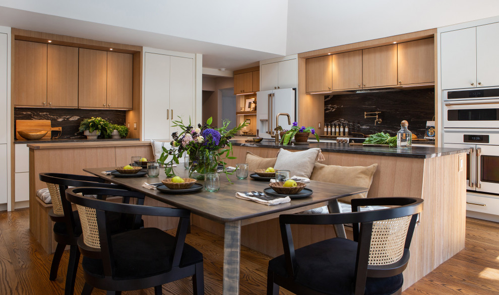 This is an example of a large contemporary u-shaped kitchen/diner in New York with a submerged sink, flat-panel cabinets, medium wood cabinets, marble worktops, multi-coloured splashback, white appliances, medium hardwood flooring, an island, brown floors and multicoloured worktops.
