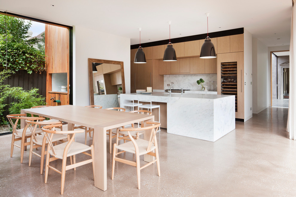 Inspiration for a large contemporary galley eat-in kitchen in Melbourne with an undermount sink, light wood cabinets, marble benchtops, stone slab splashback, concrete floors, with island, flat-panel cabinets and white splashback.