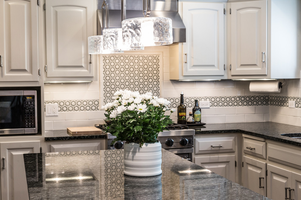 Example of a large transitional u-shaped brown floor and dark wood floor eat-in kitchen design in Chicago with an undermount sink, raised-panel cabinets, white cabinets, granite countertops, white backsplash, stainless steel appliances, an island and subway tile backsplash