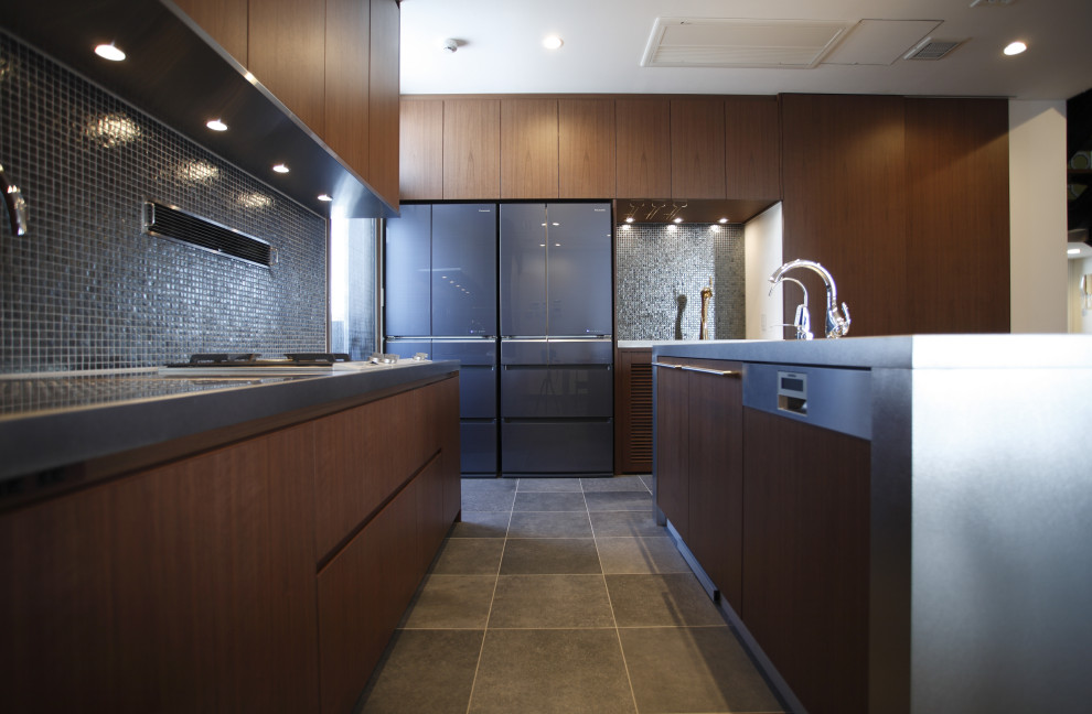 This is an example of an eat-in kitchen in Other with dark wood cabinets, stainless steel benchtops, ceramic floors, with island and grey floor.