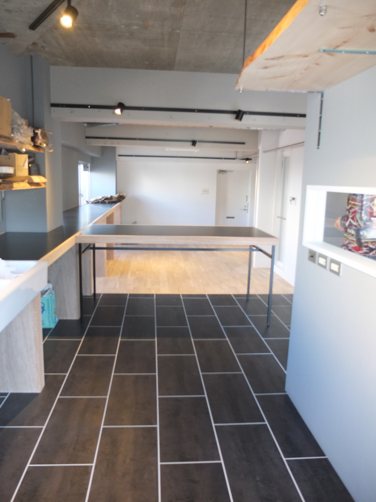 Idéer för mellanstora funkis linjära svart kök med öppen planlösning, med en dubbel diskho, öppna hyllor, träbänkskiva, svart stänkskydd, stänkskydd i trä, rostfria vitvaror, klinkergolv i keramik och svart golv