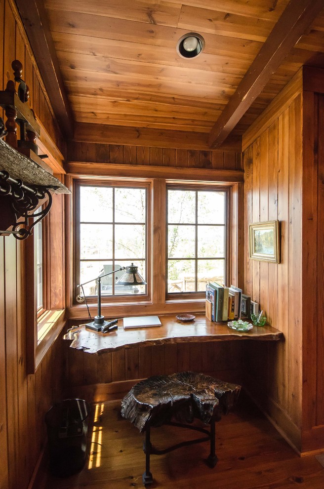 Country home office in Other with dark hardwood floors and a built-in desk.