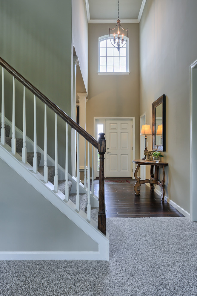 This is an example of a mid-sized traditional carpeted straight staircase in Other with carpet risers.