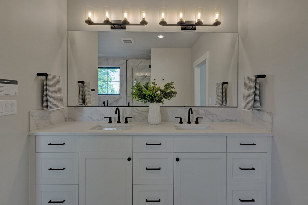 Inspiration for a large arts and crafts master bathroom in Portland with recessed-panel cabinets, white cabinets, a freestanding tub, a corner shower, a one-piece toilet, white tile, ceramic tile, grey walls, an integrated sink, engineered quartz benchtops, white floor, a hinged shower door and white benchtops.