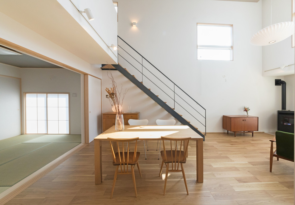 Design ideas for a midcentury dining room in Fukuoka with medium hardwood floors, a wood stove and brown floor.