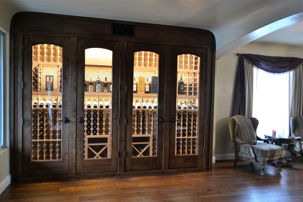 Design ideas for a mid-sized arts and crafts wine cellar in Sacramento with display racks, dark hardwood floors and brown floor.