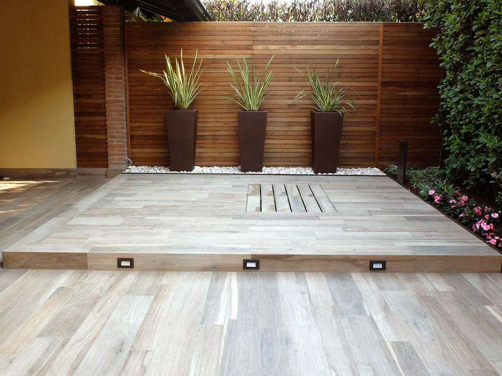 Design ideas for a small contemporary backyard partial sun formal garden for summer in Milan with decking.