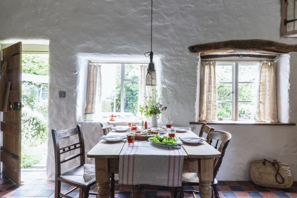 Country dining room in Other with white walls, terra-cotta floors and multi-coloured floor.