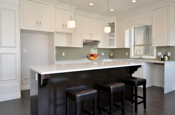Photo of a mid-sized arts and crafts l-shaped eat-in kitchen in Vancouver with raised-panel cabinets, white cabinets, quartzite benchtops, subway tile splashback, dark hardwood floors, with island and grey splashback.