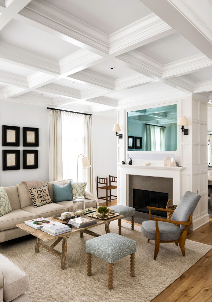 This is an example of a transitional open concept living room in New York with white walls, a standard fireplace, a stone fireplace surround, beige floor, light hardwood floors and a concealed tv.