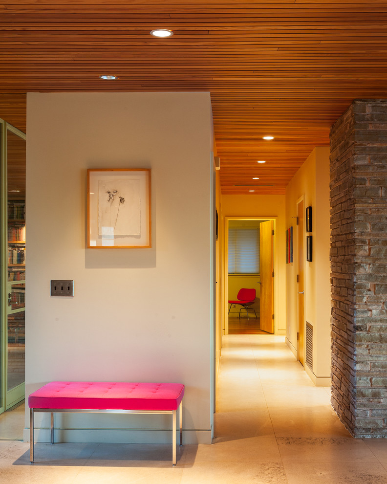 This is an example of a midcentury hallway in Austin with beige walls and limestone floors.