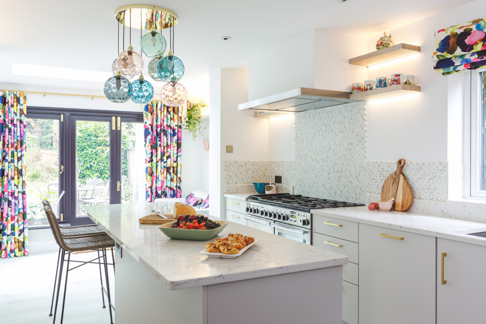 Mid-sized contemporary galley open plan kitchen in Berkshire with an integrated sink, flat-panel cabinets, white cabinets, quartzite benchtops, white splashback, glass tile splashback, stainless steel appliances, light hardwood floors, with island, grey floor and white benchtop.
