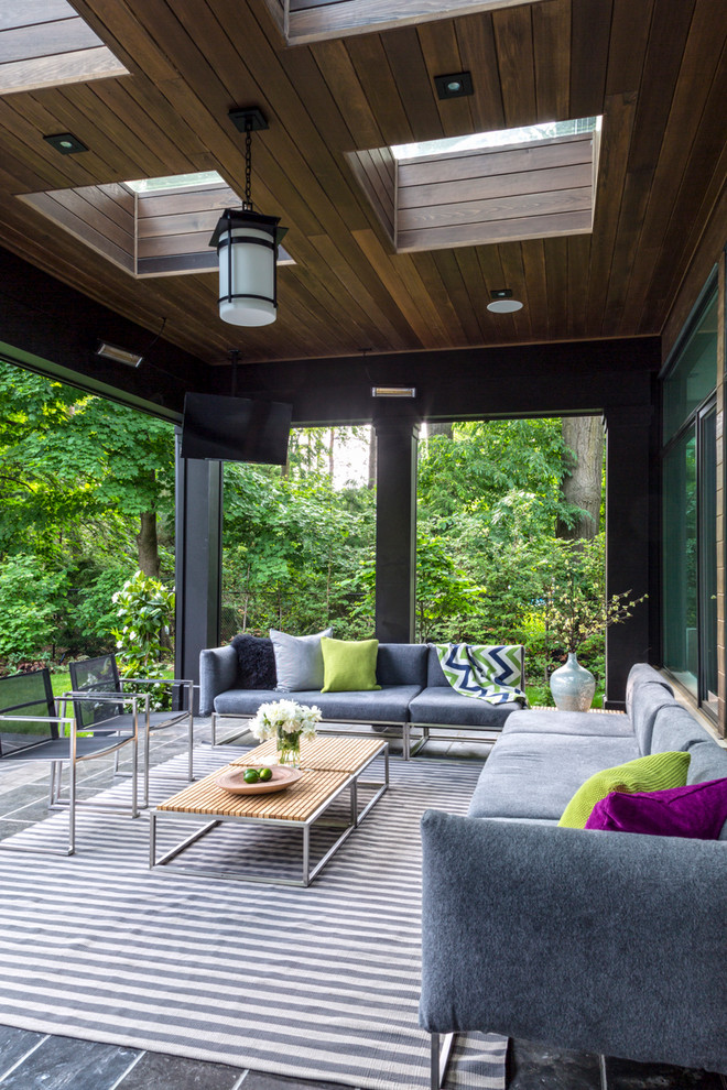 Contemporary backyard patio in Toronto with a roof extension.