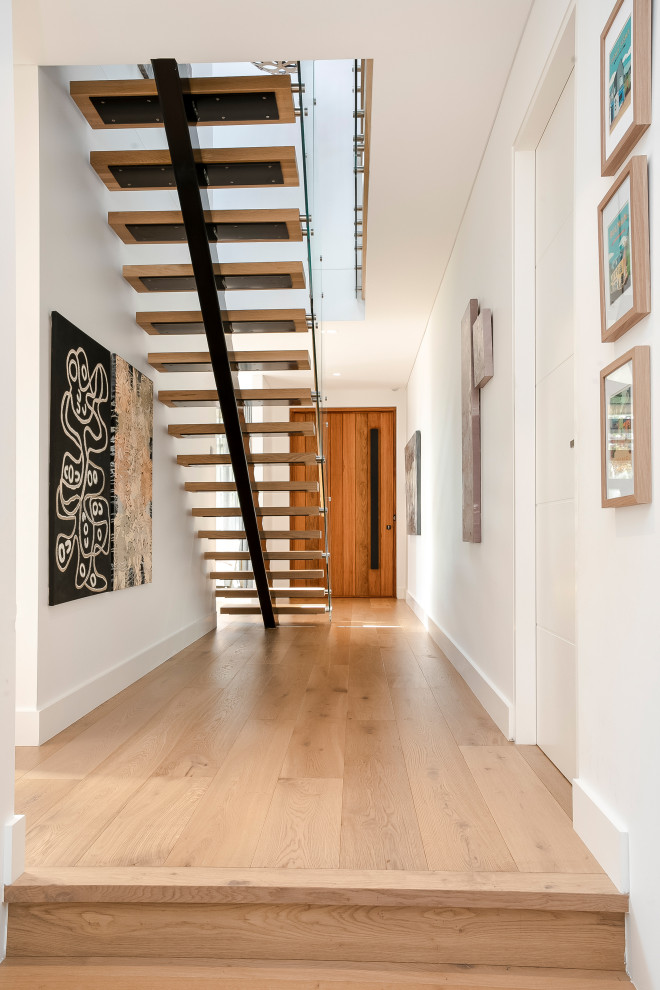 Inspiration for a large contemporary wood straight staircase in Sydney with open risers and glass railing.