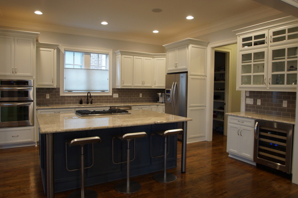 Mid-sized transitional medium tone wood floor kitchen photo in Nashville with an undermount sink, white cabinets, granite countertops, gray backsplash, stainless steel appliances and an island