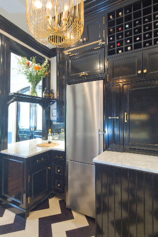 Small u-shaped separate kitchen in New York with a farmhouse sink, flat-panel cabinets, black cabinets, marble benchtops, metallic splashback, mirror splashback, stainless steel appliances, cork floors and a peninsula.
