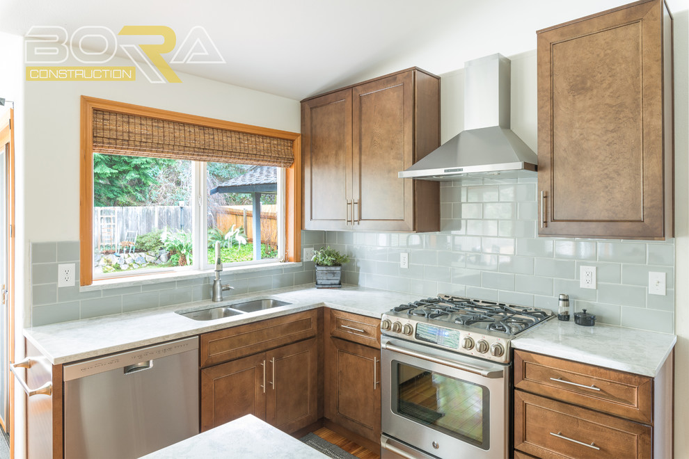 Mid-sized transitional l-shaped medium tone wood floor and brown floor eat-in kitchen photo with an undermount sink, shaker cabinets, medium tone wood cabinets, quartz countertops, gray backsplash, ceramic backsplash, stainless steel appliances and an island