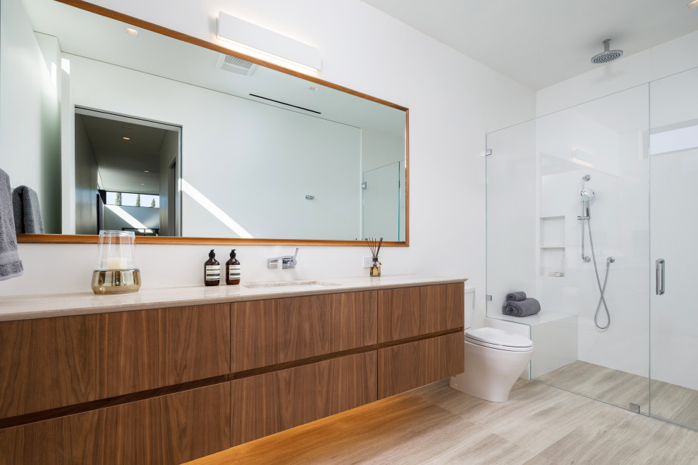 Contemporary 3/4 bathroom in Los Angeles with flat-panel cabinets, medium wood cabinets, an alcove shower, white walls, an undermount sink, grey floor, a hinged shower door, beige benchtops, a single vanity and a floating vanity.