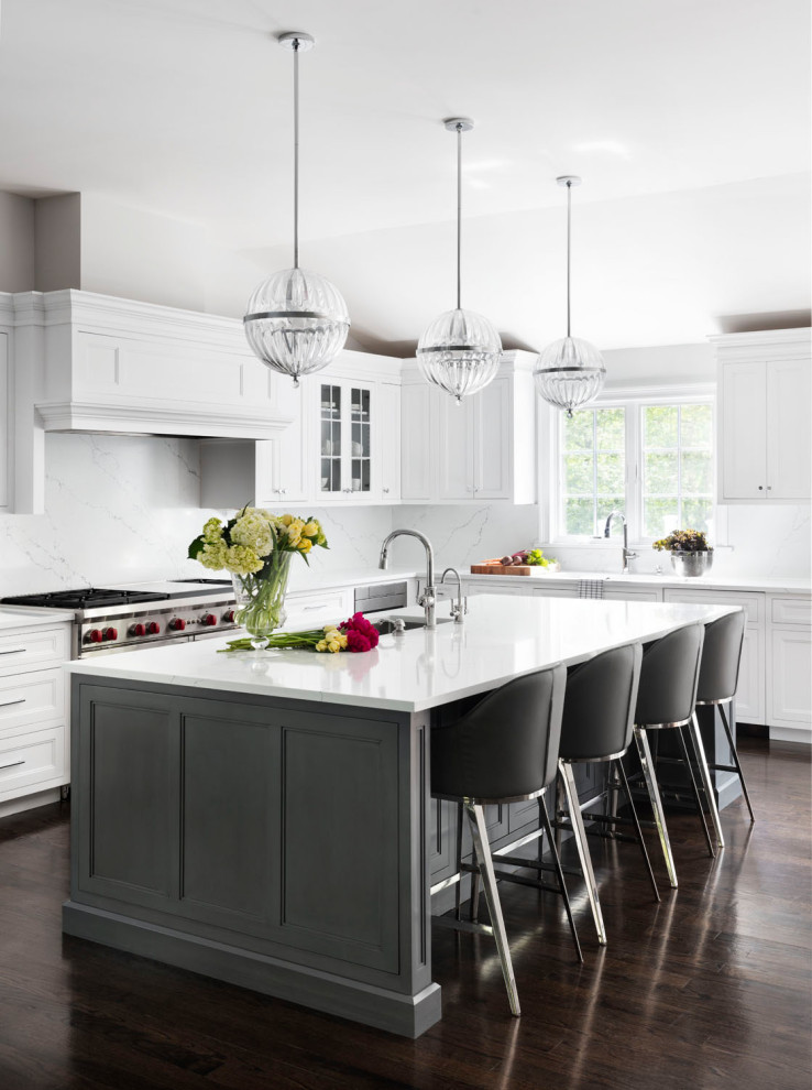 Inspiration for a large transitional l-shaped open plan kitchen in New York with an undermount sink, recessed-panel cabinets, white cabinets, white splashback, stainless steel appliances, dark hardwood floors, with island, brown floor, white benchtop, quartz benchtops and engineered quartz splashback.