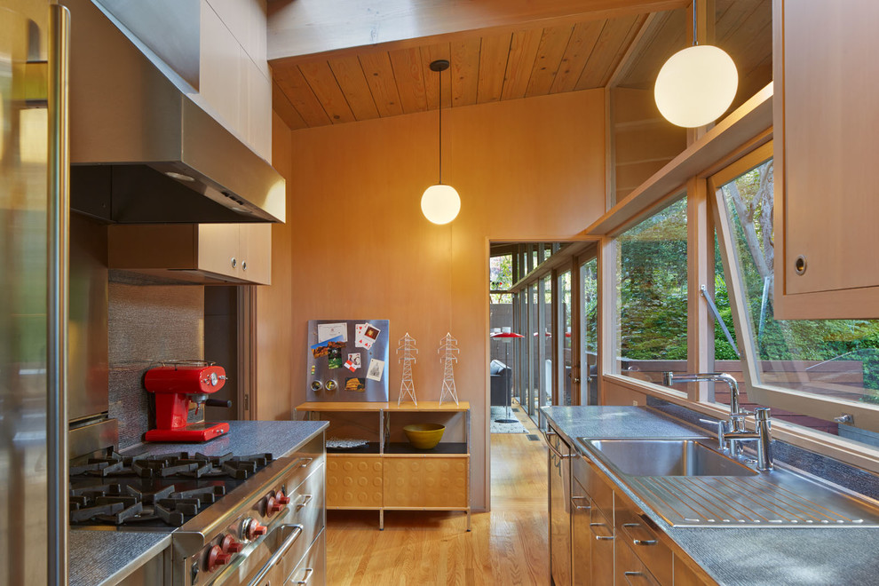 Inspiration for a small midcentury kitchen in San Francisco with a drop-in sink, stainless steel cabinets, stainless steel appliances and medium hardwood floors.