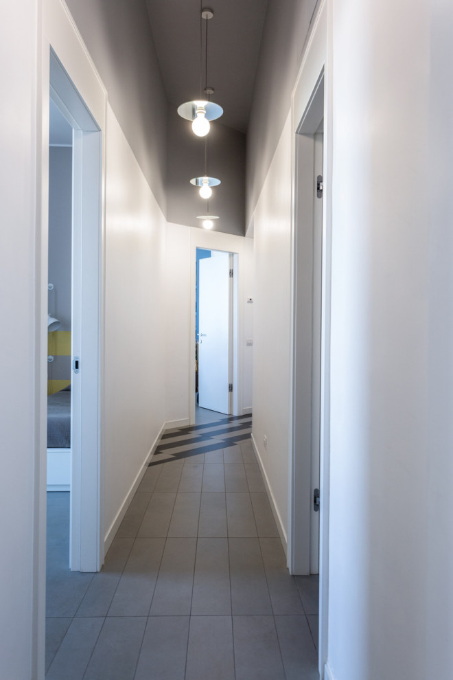 Immagine di un ingresso o corridoio minimal di medie dimensioni con pavimento con piastrelle in ceramica e pavimento grigio