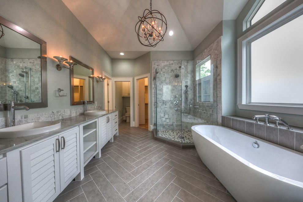 Design ideas for a large transitional master bathroom in Houston with louvered cabinets, white cabinets, a freestanding tub, a corner shower, white tile, marble, grey walls, laminate floors, a drop-in sink, engineered quartz benchtops, brown floor and a hinged shower door.