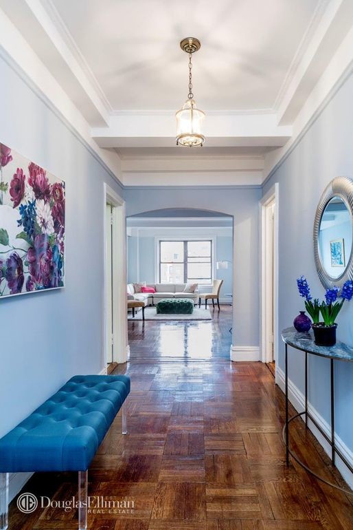 Foyer - mid-sized eclectic medium tone wood floor and brown floor foyer idea in New York with blue walls and a white front door