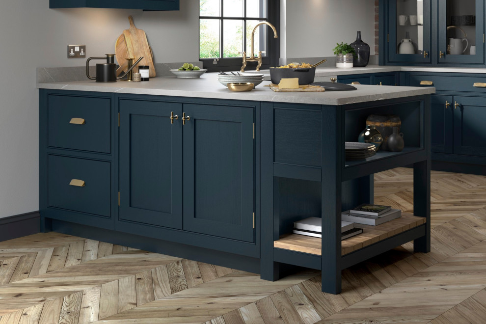 Design ideas for a mid-sized traditional l-shaped eat-in kitchen in Other with an undermount sink, shaker cabinets, light wood cabinets, quartzite benchtops, black appliances, light hardwood floors, with island and white benchtop.