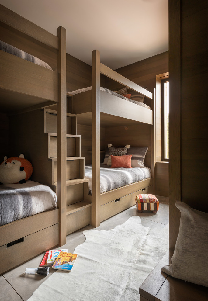 Photo of a country gender-neutral kids' bedroom for kids 4-10 years old in Seattle with brown walls, grey floor and concrete floors.