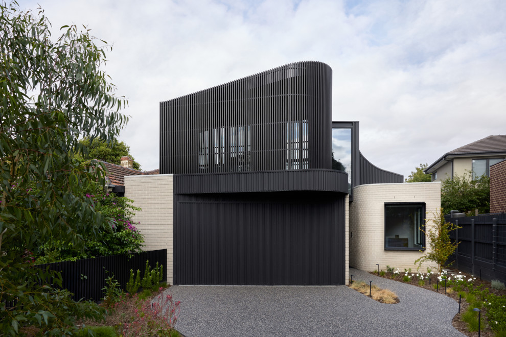 Inspiration for a mid-sized contemporary two-storey black house exterior in Melbourne with metal siding, a flat roof and a metal roof.