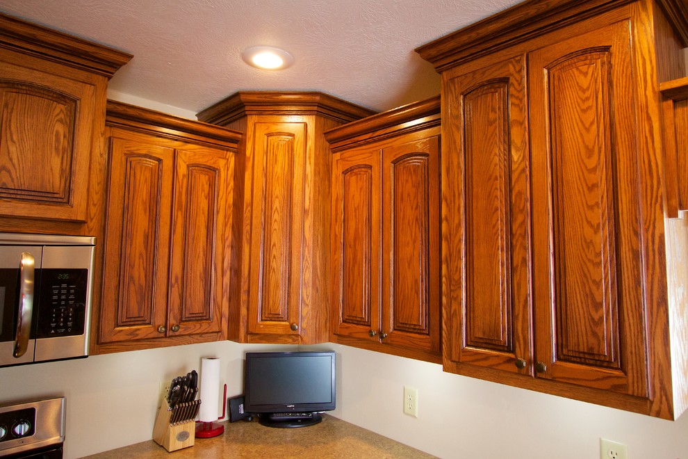 Inspiration for a mid-sized single-wall eat-in kitchen remodel with an undermount sink, medium tone wood cabinets, laminate countertops, stainless steel appliances and an island