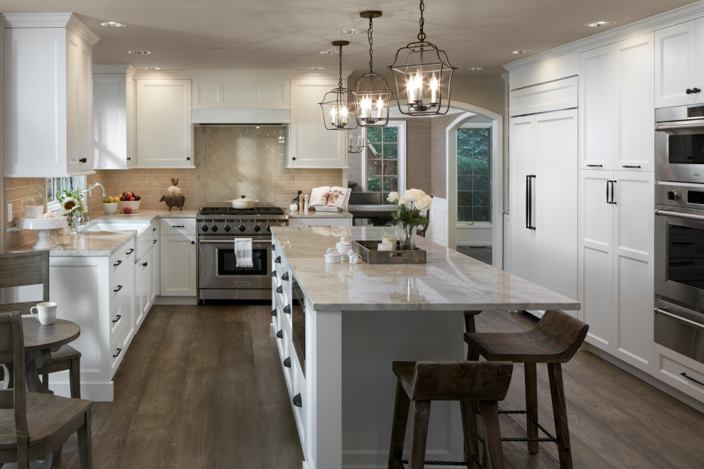 Transitional u-shaped eat-in kitchen in Seattle with a farmhouse sink, beaded inset cabinets, white cabinets, beige splashback, panelled appliances, medium hardwood floors, with island, brown floor and beige benchtop.