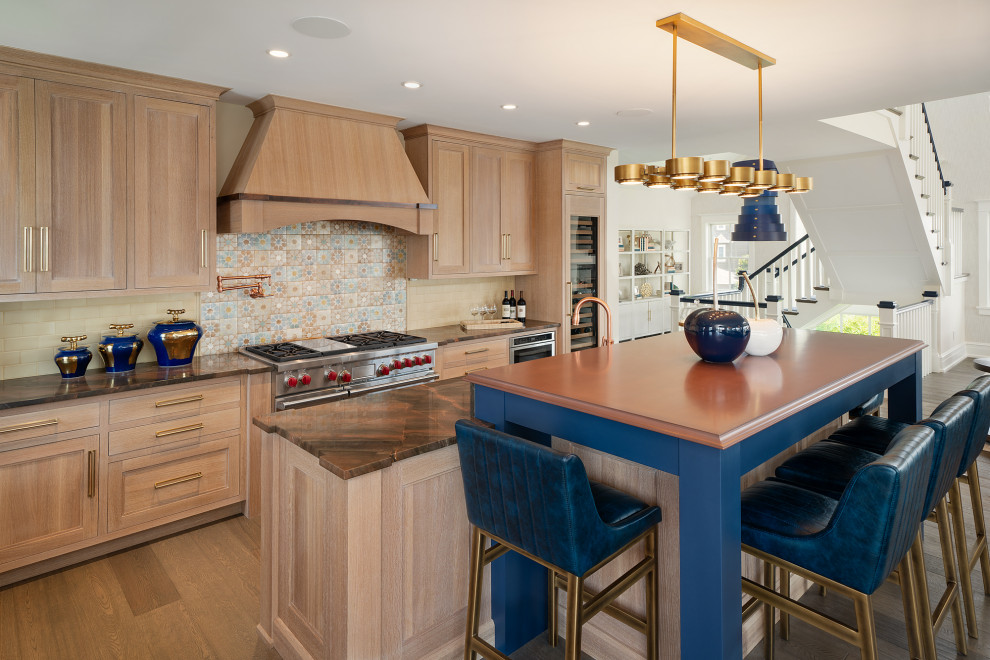 This is an example of a large beach style l-shaped open plan kitchen in Philadelphia with an undermount sink, light wood cabinets, zinc benchtops, beige splashback, ceramic splashback, stainless steel appliances, medium hardwood floors, with island, beige benchtop and shaker cabinets.